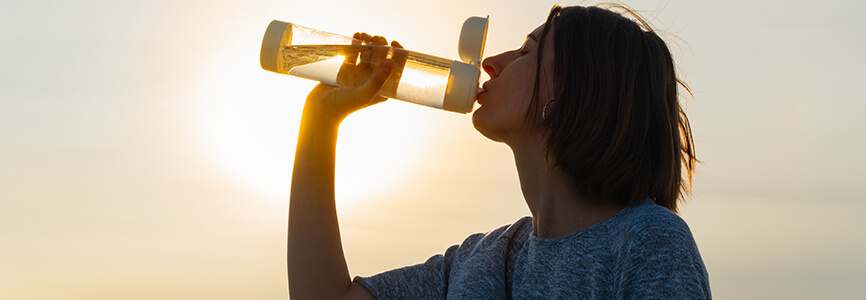 woman drinking from reusable water bottle